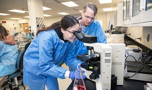 Student in a microbiology lab with instructor